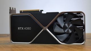 An Nvidia GeForce RTX 4080 on a wooden desk in front of a white panel