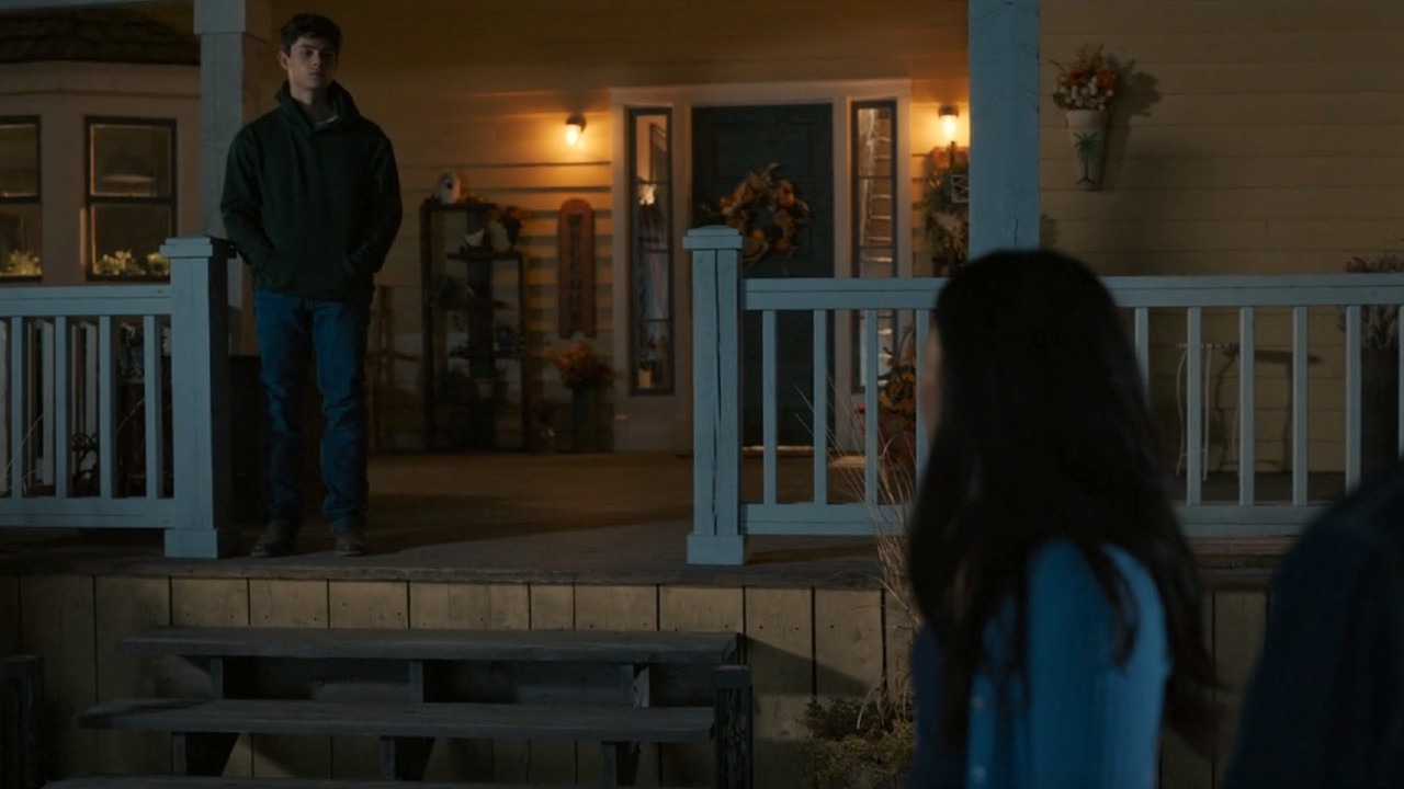 Alex standing on the porch as Jackie looks back at him in My Life with the Walter Boys.