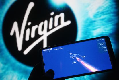 The Virgin logo behind a picture of a rocket on a screen