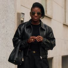 Nikki Ogunnaike wearing a black leather jacket, a black top, and black trousers during Milan Fashion Week 