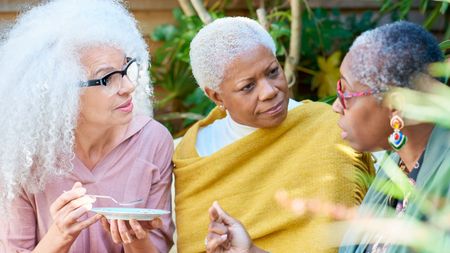 three women chatting in a garden 