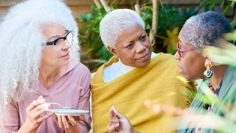 three women chatting in a garden