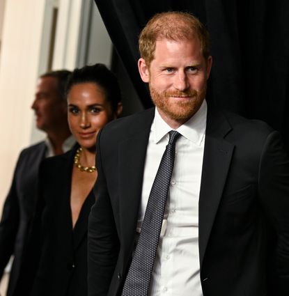 Meghan Markle and Prince harry wearing black suits