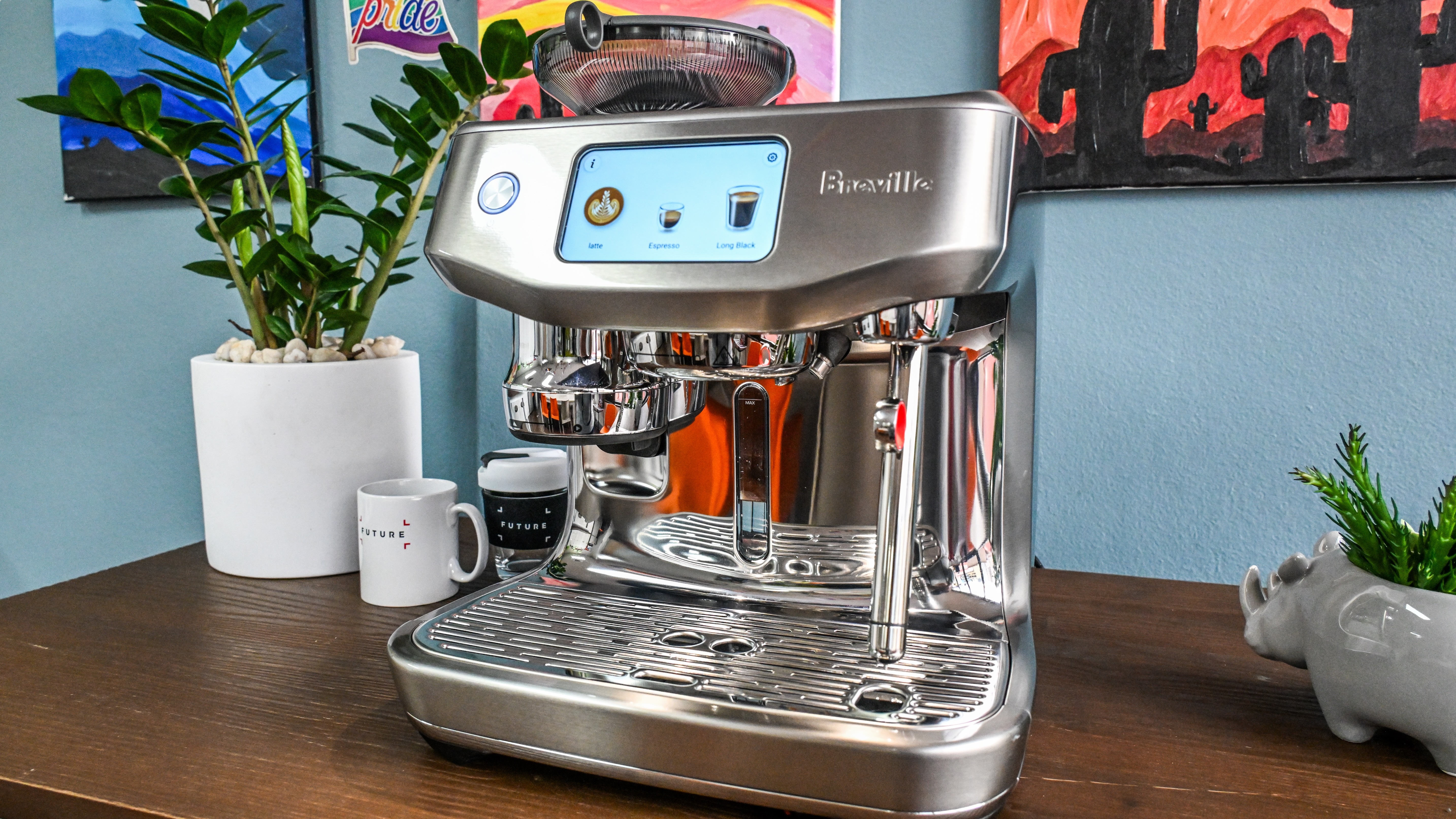 A slightly acute front-on image of the Breville Oracle Jet coffee machine sitting on a brown wooden table.