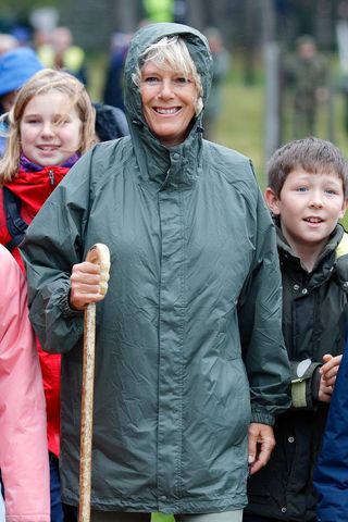 Queen Camilla leading a charity walk in a green raincoat