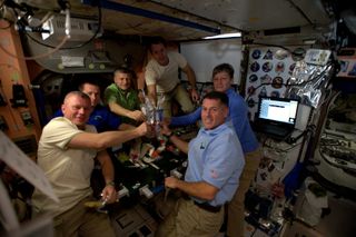 The six-person crew of Expedition 50 celebrate a very happy Thanksgiving on the International Space Station on Nov. 24, 2016 with rehydrated turkey, stuffing, potatoes and vegetables.