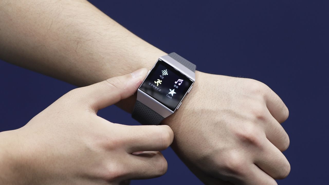 An attendant shows a Fitbit Inc. Ionic smartwatch for a photograph at the Wearable Expo in Tokyo, Japan, on Thursday, Jan. 18, 2018. The trade show featuring wearable devices and technologies runs through to Jan. 19. 