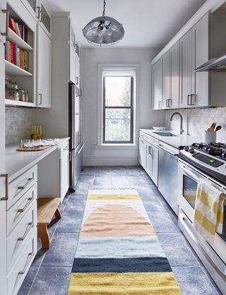 A kitchen with dark floor tiles