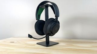 The SteelSeries Arctis Nova 7X on a headphone stand on a wood table