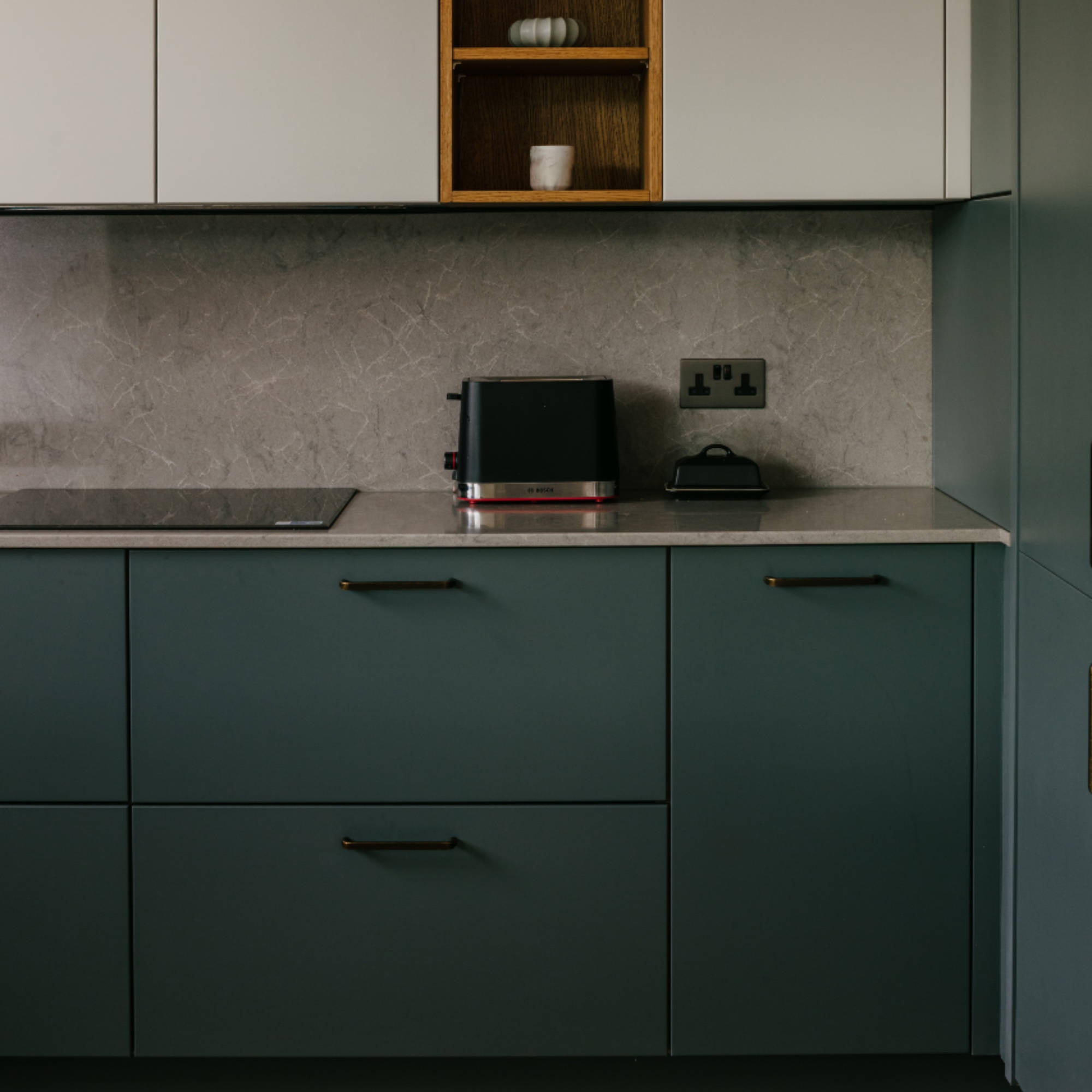 teal and off white cabinetry with taupe worktops