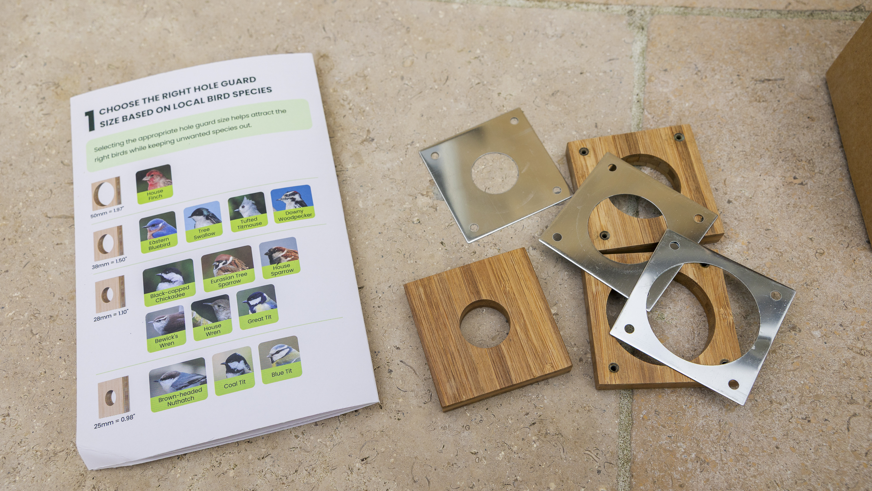 Three different-sized holes laid out on a patio for the Birdfy Nest Duo box