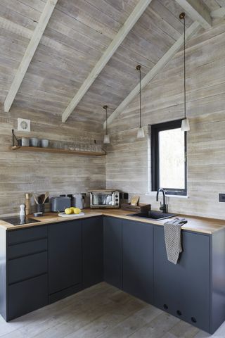 modern blue kitchen with wall and ceiling timber cladding