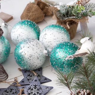 Close up of silver and blue Christmas tree ornaments and star shapes and wooden box.