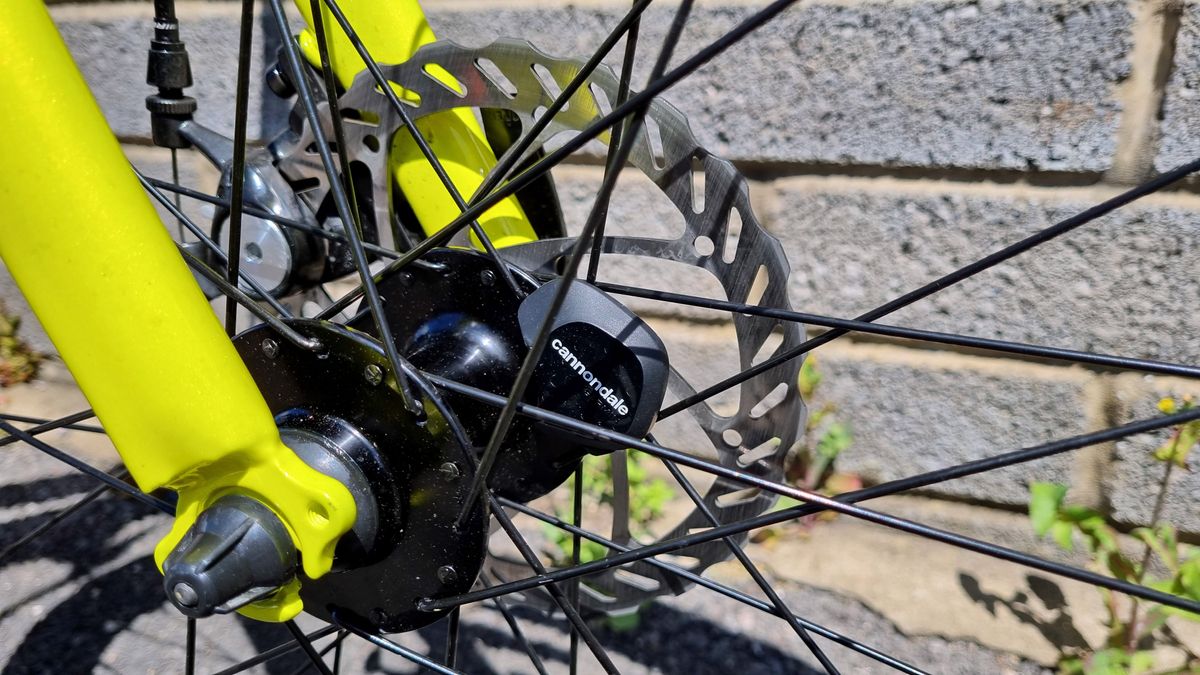 A close up of the wheel sensor mounted on the inside of a yellow fork