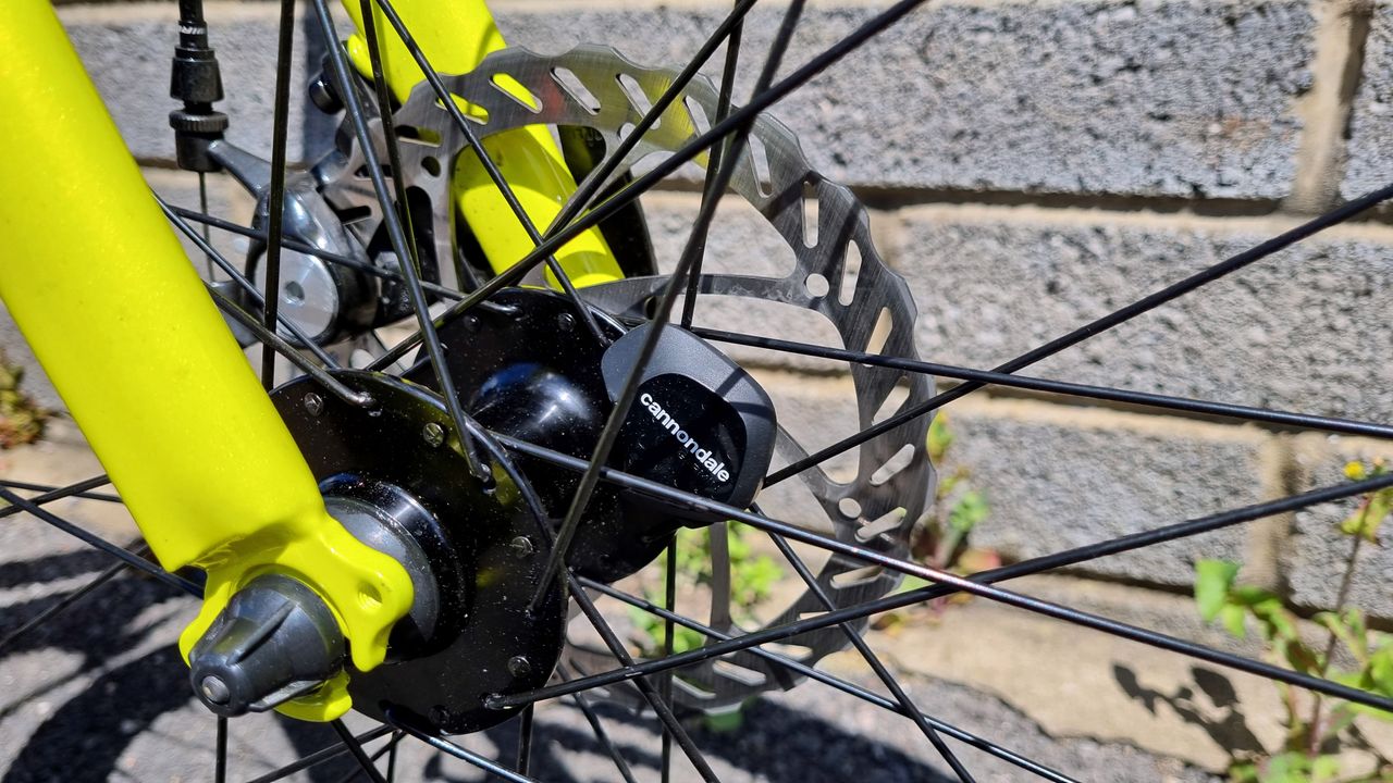 A close up of the wheel sensor mounted on the inside of a yellow fork