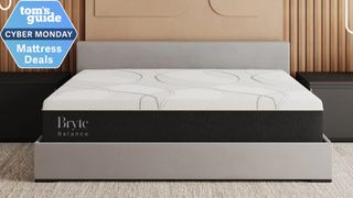 Bryte Balance Smart Bed on a taupe upholstered bed frame, with a Tom's Guide Cyber Monday mattress deal badge in the top left corner