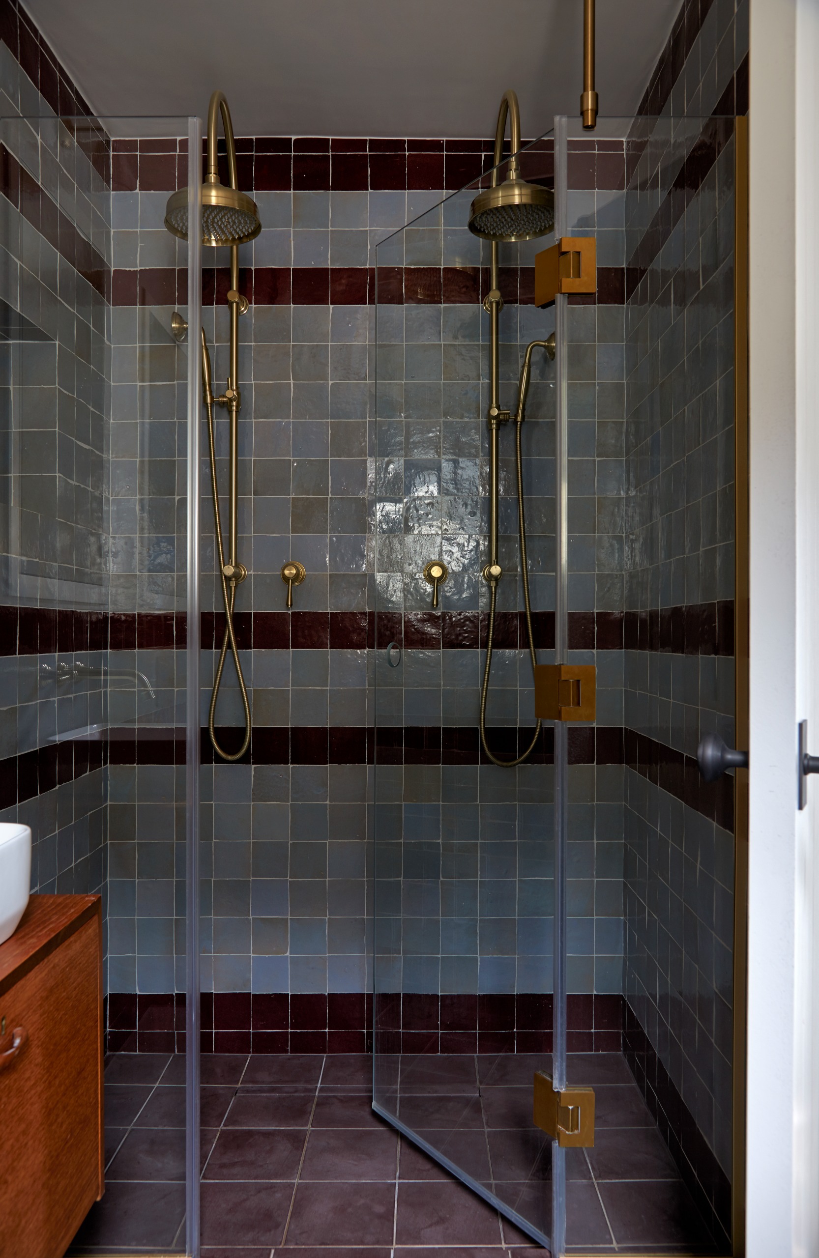 walk in double shower enclosure with blue and brown striped zellige tiles
