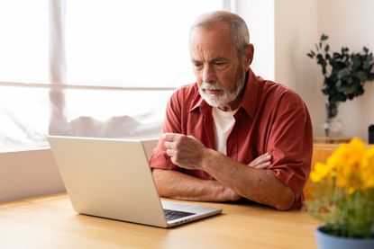 Senior man using laptop at home