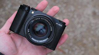 Fujifilm X-M5 camera with a Fujifilm 35mm lens attached held in a hand