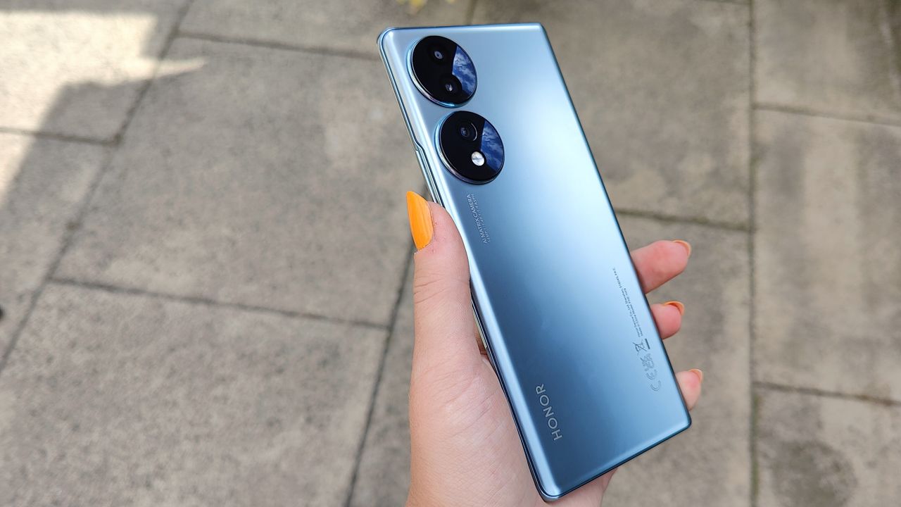 Honor 70 review: holding phone with orange nails