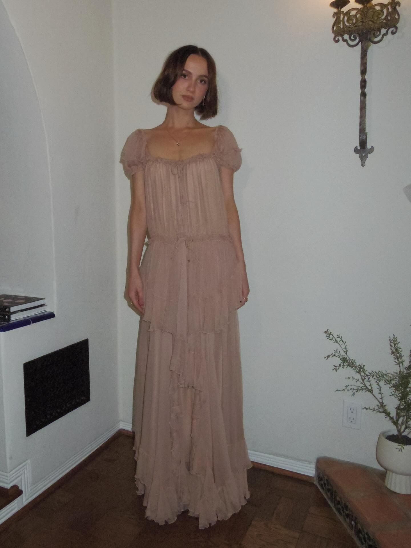 An image of actress Maude Apatow with her hair in a short, wavy bob and flowing Chloé floor-length dress.