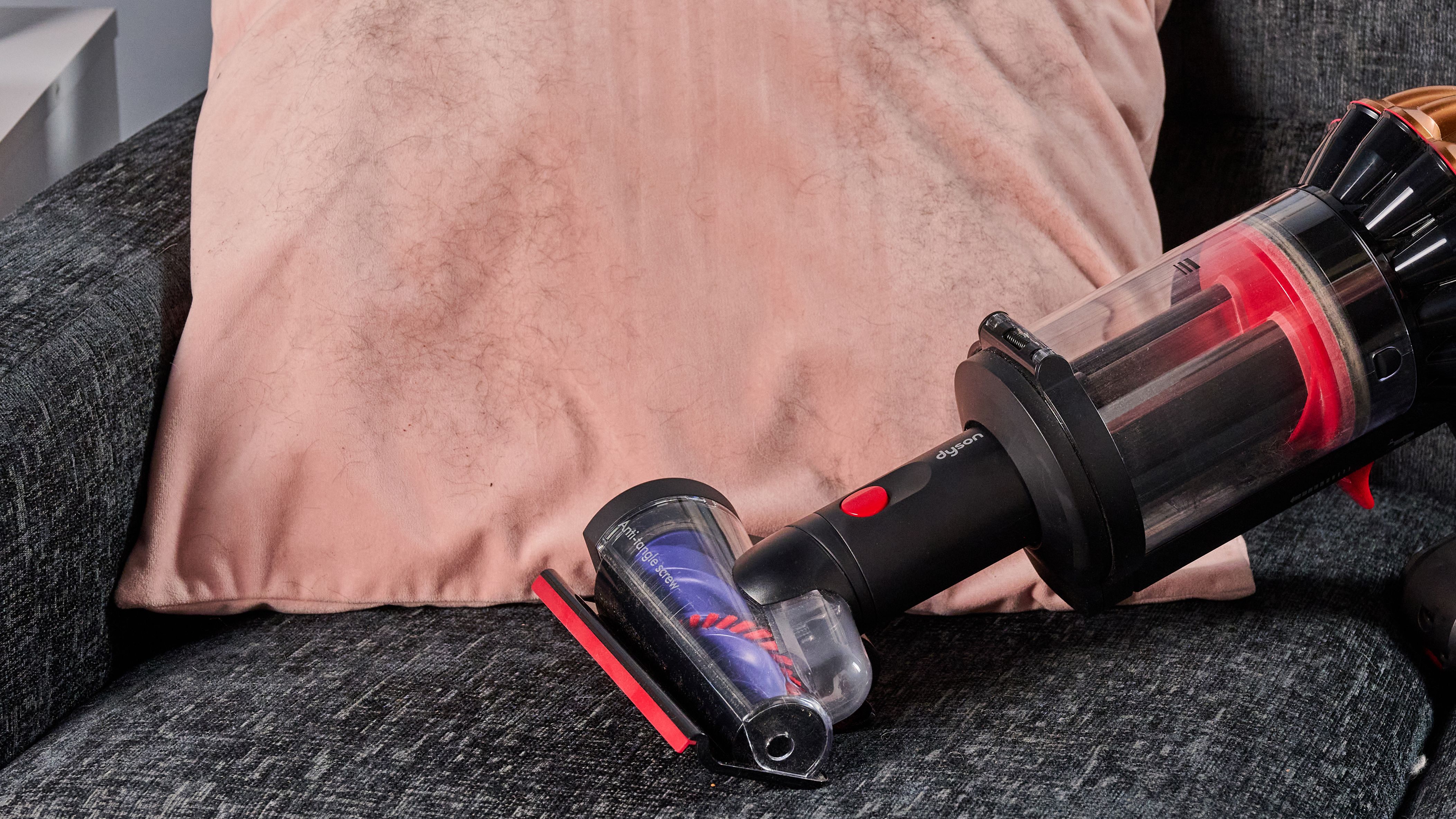 Dyson V16 Piston Animal vacuum with updated Hair screw tool, lifting pet hair from a velvet cushion