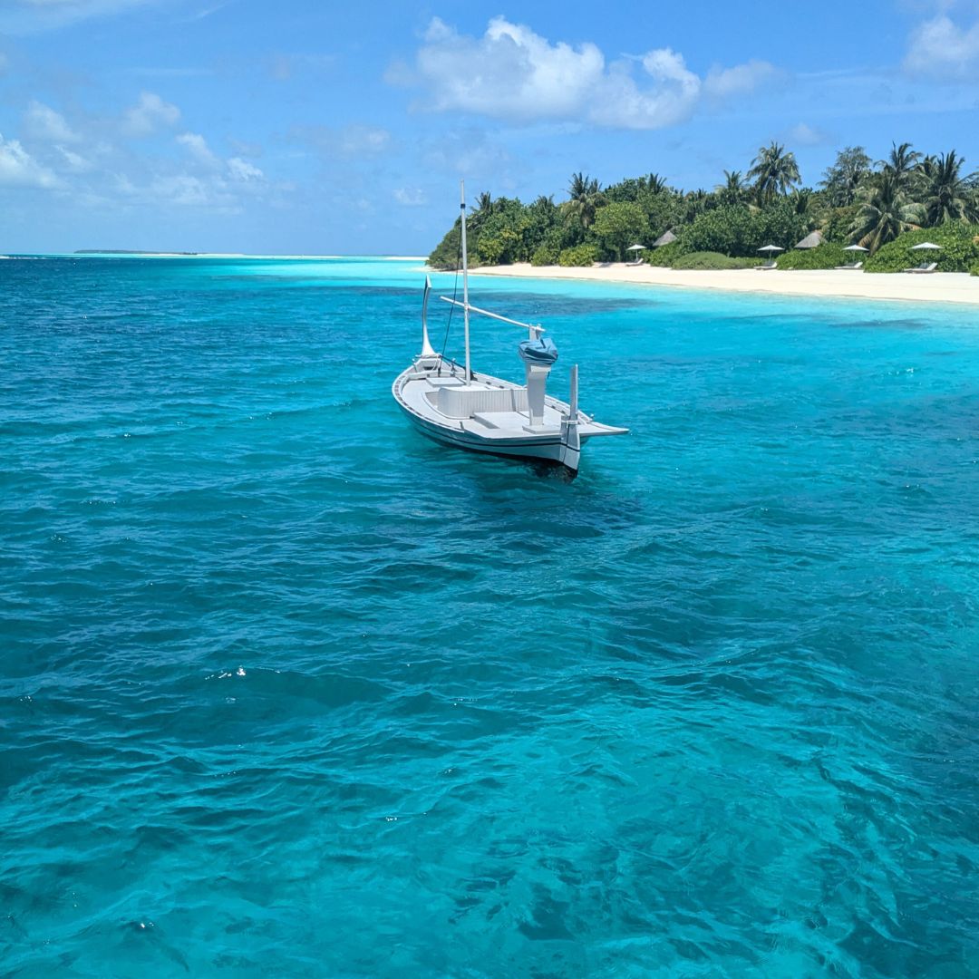 Little white boat on the ocean close to Landaa Giraavaru, Maldives