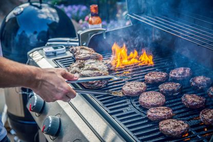 A press image of burgers and steaks cooking on the best gas grills