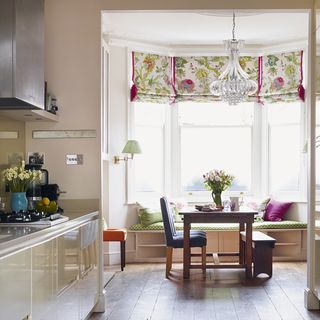 kitchen with window and flower pot on table and chairs