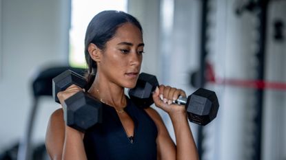 A woman holding a pair of dumbbells