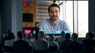 A man is on a large display for a videoconferencing.