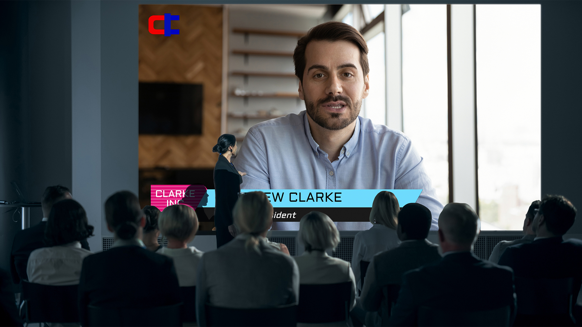 A man is on a large display for a videoconferencing. 