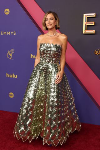 Kristen Wiig wears an Oscar de le Renta metallic strapless gown.