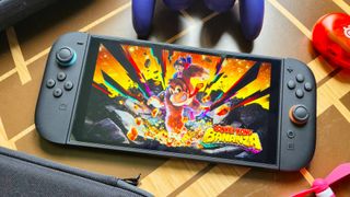 Switch 2 with Donkey Kong Bananza art on screen on wood pattern table next to accessories.