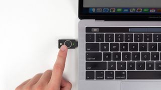 A Yubico YubiKey Bio with a fingerprint reader plugged into an Apple MacBook.