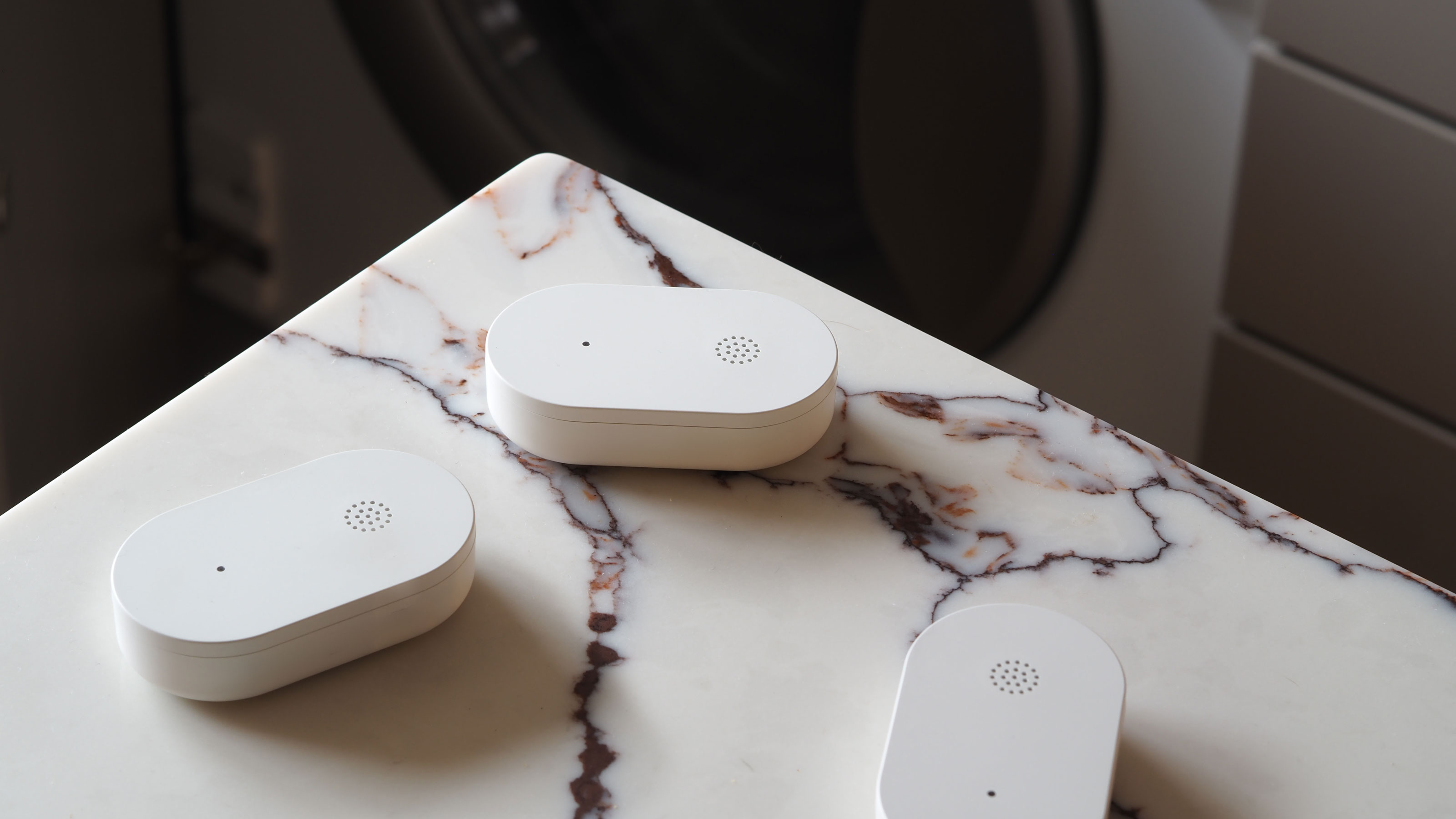 ikea klippbok water sensor on a marble background with a washing machine in the back