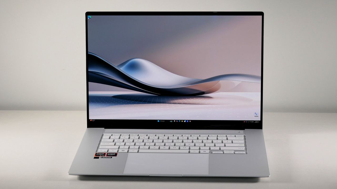 Asus Zenbook S16 UM5606 (Ryzen AI 9) open on a white desk showing facing the camera directly and showing the desktop on the display.