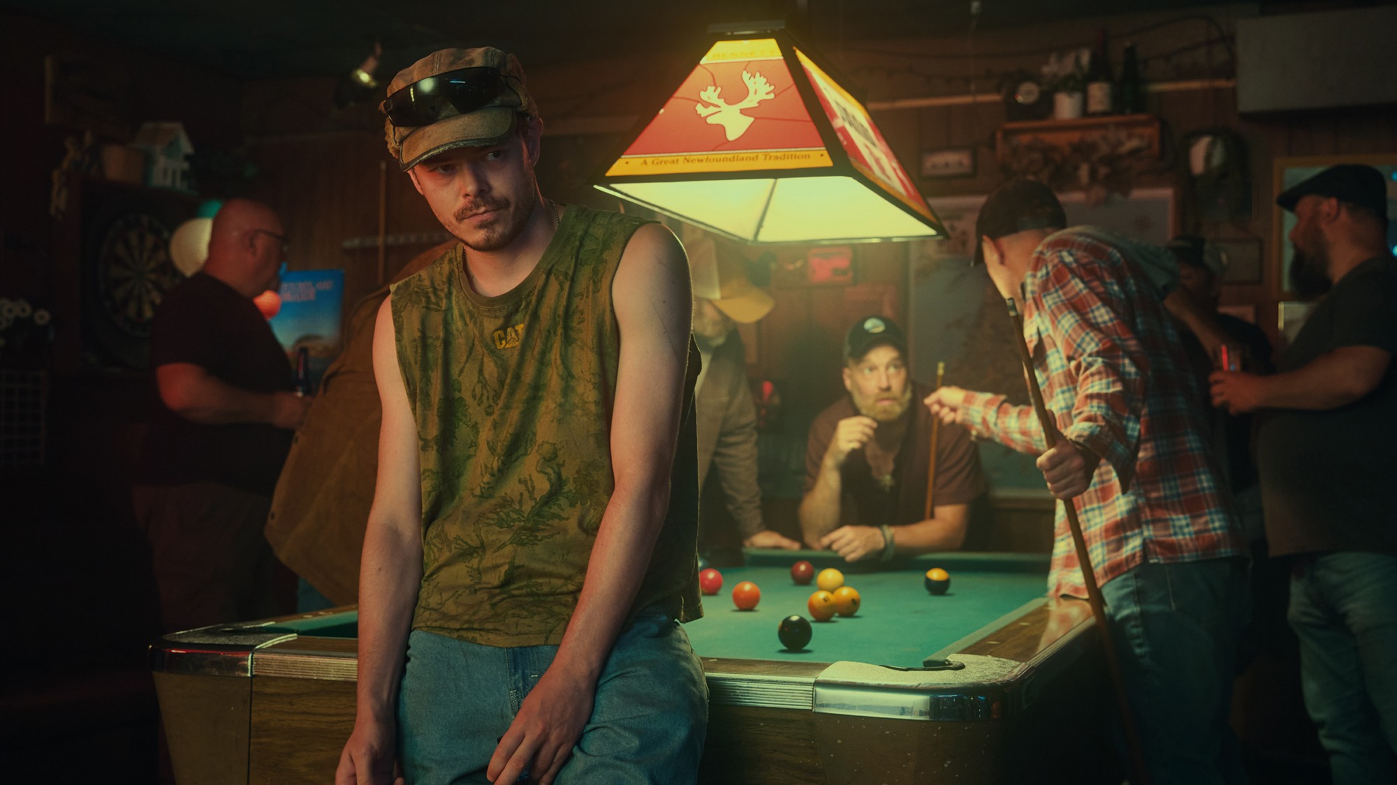 Wade hanging out at the bar while people play pool behind him.