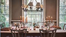Dining table with candelabras, colored glassware and flowers in bud vases