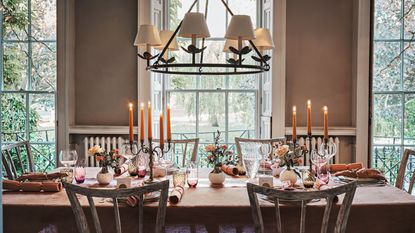 Dining table with candelabras, colored glassware and flowers in bud vases