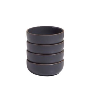 A stack of four dark charcoal colored circular bowls