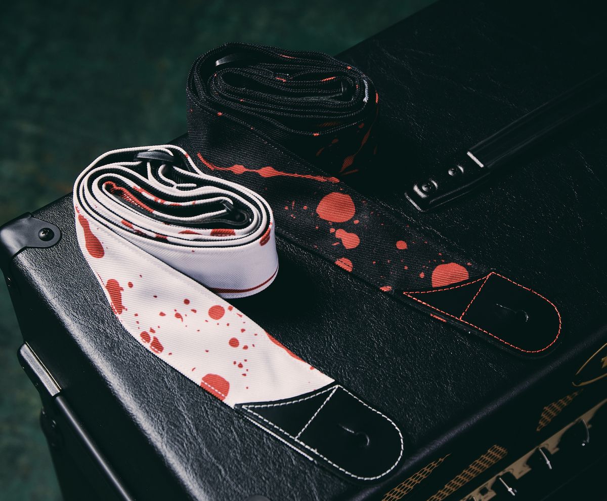 Two of Jackson's new guitar straps lie on a guitar amp