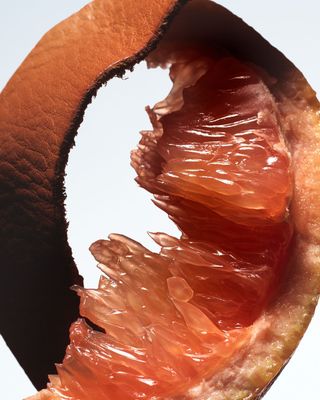 A close up still life of a grapefruit and piece of leather