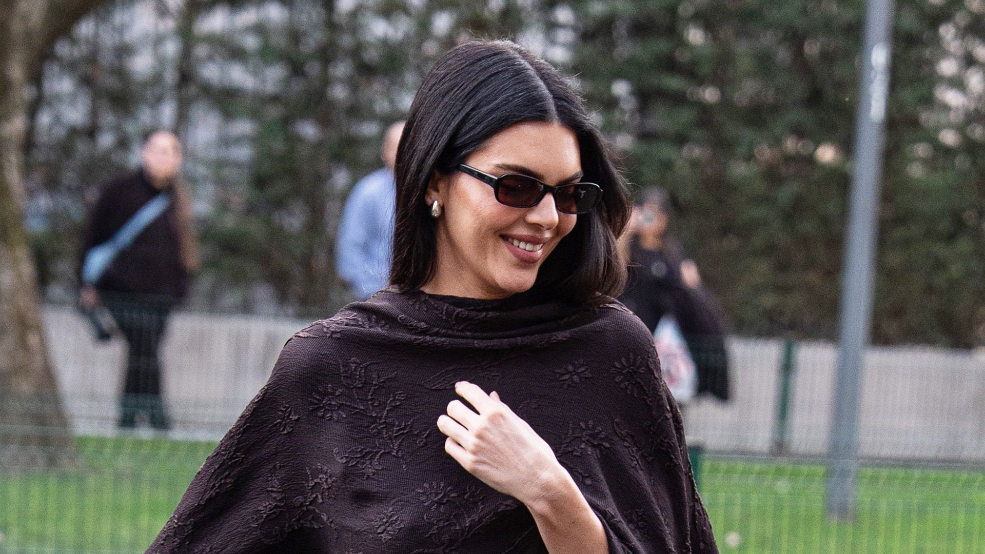 Kendall Jenner wearing a silk, cape, fitted dress, and strappy high-heel sandals in Milan.