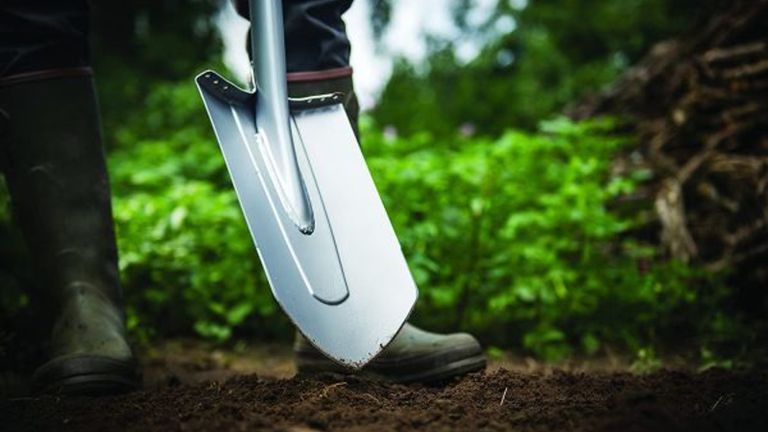 person using the Fiskars Xact Large Digging Spade outside, one of the best gardening tools on our list