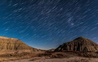 Orion rising in star trails and in the moonlight, at Dinosaur Provincial Park, Alberta, on November 27, 2017 Light is from the 8-day waxing Moon off camera to the right This is a stack of 100 exposures for the star trails, followed by a gap of a miniute, then a final single exposure to add the point-like stars at the ends of the trails Another gaussian blur layer adds the star glows The 100 star trail frames were extracted from the end of a 1200-frame time-lapse sequence All exposures were 10 seconds at f/2 with a 24mm Sigma Art lens and Nikon D750 at ISO 800 Stacking was with the Advanced Stacker Plus actions from Star Circle Academy, v14e.