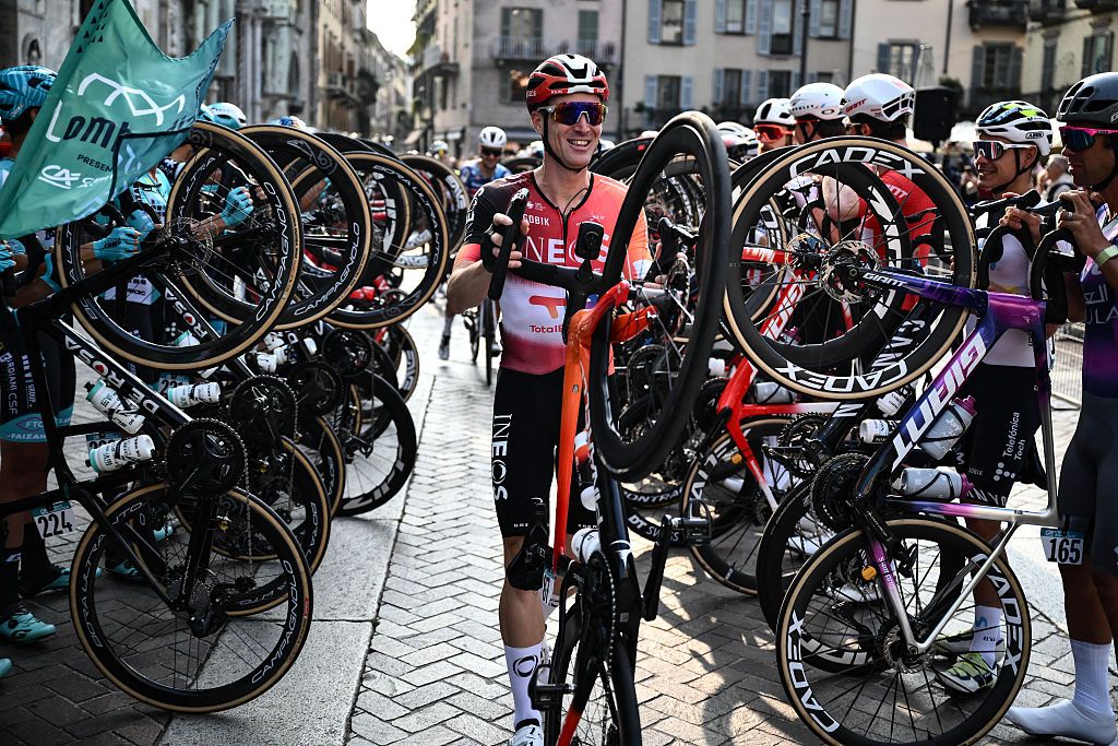 Ineos Grenadiers&rsquo;s Italian rider Salvatore Puccio walks his bicycle past riders lining the start area to celebrate his last race ahead of the 119th edition of the Giro di Lombardia (Tour of Lombardy), a 238km cycling race from Como to Bergamo on October 11, 2025. (Photo by Marco BERTORELLO / AFP)