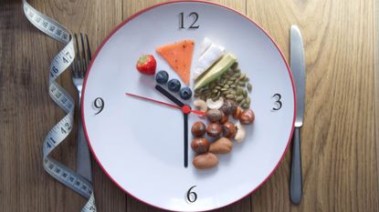 A plate with numbers on it like a clock and healthy foods.