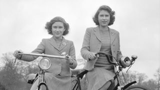 A young Princess Elizabeth and Princess Margaret pose for photos as they ride bikes