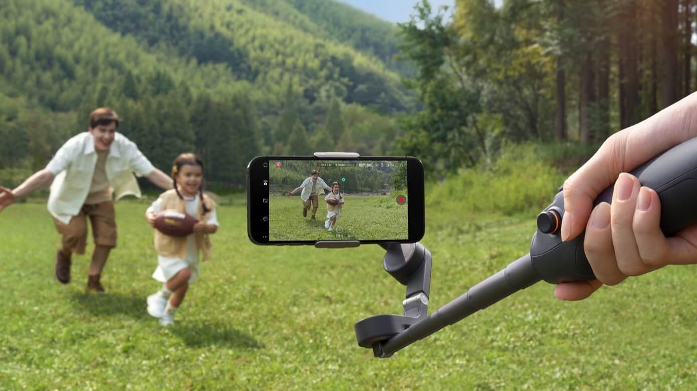 The DJI OM 6 being used to fil people running in a field